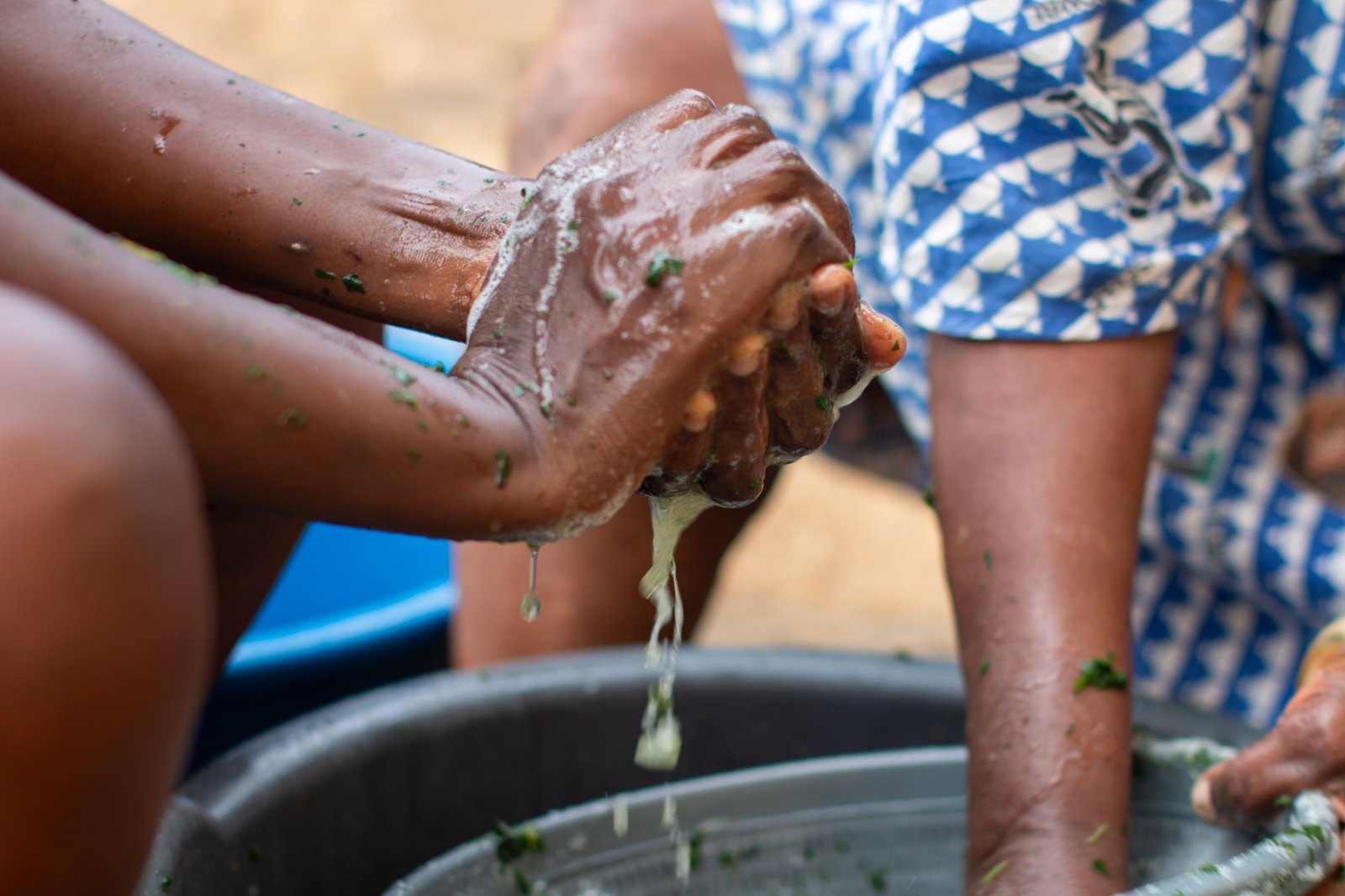 Hands preparing leafy ingredients together